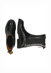 Botines de cuero negro con detalles de brogue, paneles laterales elásticos y una suela de goma gruesa, que cuentan con una lengüeta en la parte posterior.