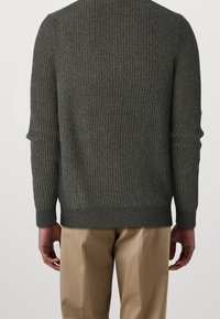 Tummanharmaa resorineulottu neulepaita pyöreällä pääntiellä ja pitkillä hihoilla, jossa on istuva helmallinen leikkaus ja hillitty tekstuuri.