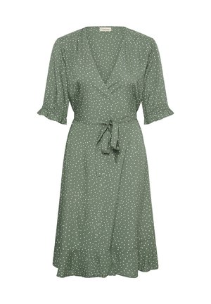 Vestido cruzado verde con lunares blancos, mangas cortas abullonadas con puños con volantes, cinturón en la cintura y falda acampanada con un dobladillo con volantes.