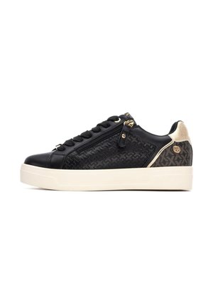 Zapatillas negras de cuero texturizado, con herrajes dorados y un detalle de cremallera. Suela color crema, panel trasero con un acento estampado. Diseño de caña baja.