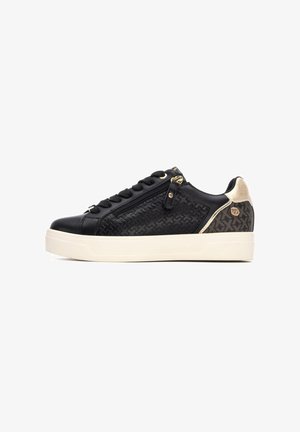 Zapatillas negras de cuero texturizado, con herrajes dorados y un detalle de cremallera. Suela color crema, panel trasero con un acento estampado. Diseño de caña baja.