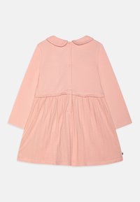 Rosa långärmad klänning med rund krage, med en texturerad byst och lätt veckad kjol, som knäpps med knappar bak.