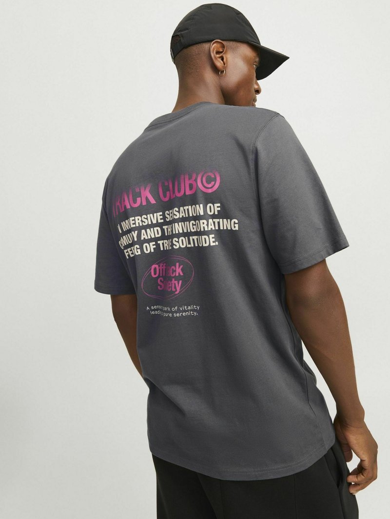 T-shirt en coton gris à manches courtes, avec un texte multicolore au dos : lettres roses et blanches sur un fond sombre.