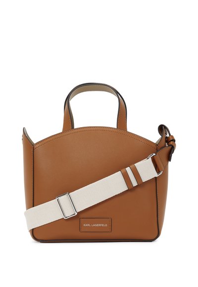Sac à main en cuir marron avec un dessus arrondi, des poignées courtes et une courroie crème amovible. Une boucle en argent et un logo sur le devant ajoutent des détails.