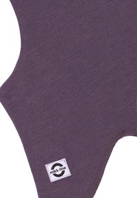 Fioletowa dzianina o gładkiej fakturze, z zaokrąglonymi krawędziami i małą czarno-białą metką z logo mikk-line.