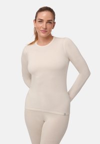 Langärmliges Thermoshirt aus weichem Creme-Stoff, taillierte Form mit gerippter Struktur, runder Ausschnitt und minimalem Markenlogo am Saum.