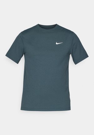 Ciemnoniebieska koszulka z krótkim rękawem, wykonana z miękkiego materiału, z białym logo Nike na lewej piersi. Klasyczny krój z okrągłym dekoltem.