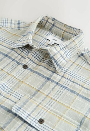 Camicia a quadri nelle tonalità di verde, blu e giallo. Tessuto morbido, colletto a bottoni e taschino sul petto. Bottoni marroni con una texture intrecciata.