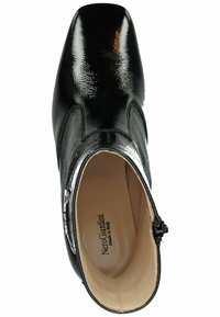 Schwarze Leder-Stiefelette mit spitzem Zeh, glänzender Oberfläche, seitlichem Reißverschluss und hellfarbiger Innensohle. Verfügt über dezente Nähte.