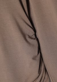 Brauner Stoff mit geraffter Textur, glatter Oberfläche und drapiertem Design, das weiches, dehnbares Material zeigt.