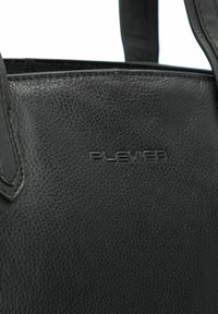 Schwarze Leder-Tote mit strukturierter Oberfläche, ausgestattet mit einem geprägten Logo und gesteppten Akzenten an den Griffen. Einfaches und funktionales Design.