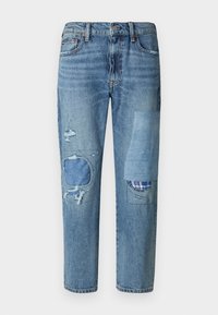 Light blue jeans made of denim with a loose fit, featuring distressed areas, patch accents, and frayed edges.