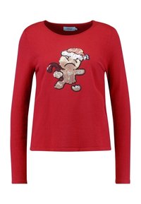 Pull rouge à manches longues de Noël avec un bonhomme en pain d'épice triste portant un chapeau de Père Noël et tenant un canne en sucre d'orge.