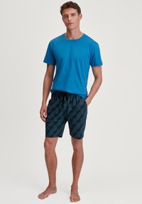Blue cotton t-shirt and patterned navy shorts with geometric white lines. Styled for comfort and casual wear, featuring an elastic waistband.