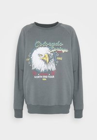 Šedá mikina s dlouhými rukávy, s předním motivem orla a textem "Colorado Springs" a "North End Tour USA".
