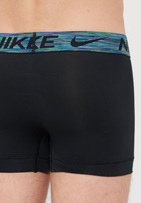 Zwarte boxer briefs met een meerkleurige, gestreepte tailleband met het Nike-logo. Glad materiaal zonder zichtbare patronen of texturen.