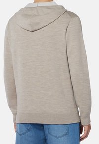 Beige hoodie med ribbad nederkant och ärmslut, med en mjuk textur och subtilt melerat mönster. Bakvy. Avslappnad passform.