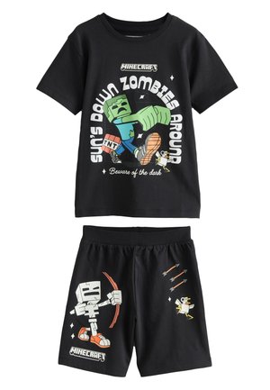 Ensemble deux pièces noir sur le thème de Minecraft comprenant un t-shirt à manches courtes avec un graphisme de zombie et un short avec un design de robot et des flèches.
