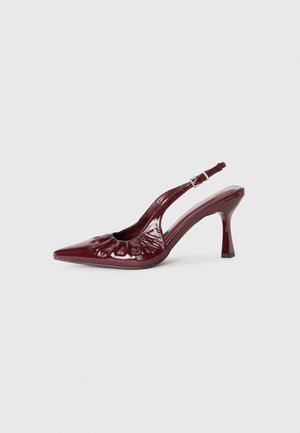 Sapatos de salto slingback em pele verniz burgundy com bico fino e detalhes franzidos, apresentando um salto delgado e uma tira ajustável no tornozelo.