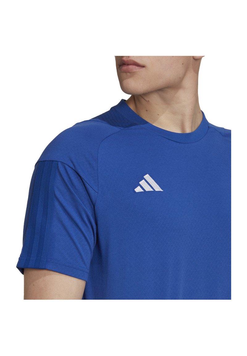 T-shirt sportivo blu a maniche corte, con collo tondo, tessuto testurizzato e logo con tre strisce diagonali bianche sul petto.