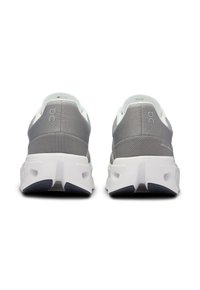 Baskets de sport grises avec une tige en maille texturée et des accents blancs, un col rembourré et une semelle épaisse blanche avec une semelle extérieure bleu foncé.