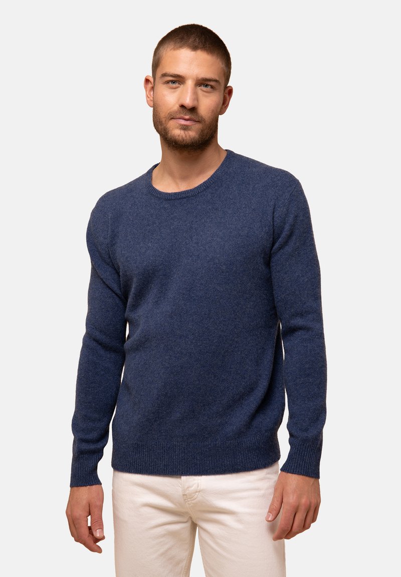 Navyblauer Wollpullover mit Rundhalsausschnitt und langen Ärmeln. Hat eine weiche Textur und eine taillierte Passform. Trägt man über hellen Hosen.
