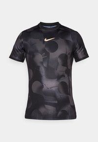Černé tričko Nike s krátkým rukávem s hladkou texturou a jemným grafickým vzorem tmavých kruhů, se zlatým logem na hrudi.