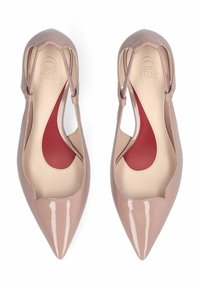 Paire de ballerines slingback vernies couleur chair à bout pointu, avec semelles intérieures beige et rouge, vues de dessus sur fond blanc.