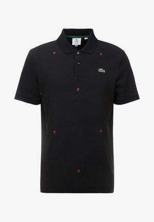 Polo shirt noir en coton, ornée de broderies de roses rouges sur l'ensemble et d'un logo vert sur la poitrine. Manches courtes et design de col.