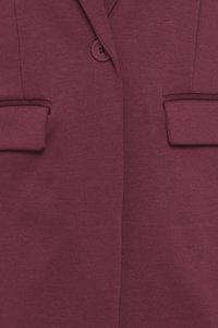 Skräddarsydd burgundyröd blazer med en jämn textur, som har en enkel knappstängning och två framfickor med klaffar.