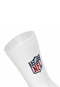 Vit bomull crewstrumpa med ribbad textur, som har en röd NFL-logotyp med blå detaljer på den övre delen.