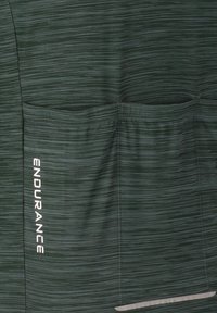 Dunkelgrünes Sportshirt mit strukturiertem Stoff und horizontalen Streifen, zwei Seitentaschen und dem weißen "ENDURANCE"-Logo.