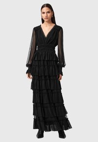Vestito maxi nero con rouches a strati, maniche lunghe trasparenti e scollatura a V profonda. Presenta una vita increspata e dettagli in tessuto texturizzato.