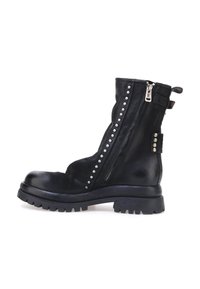 Crne kožne gležnjače sa srebrnim zakovicama sa strane, teksturiranom površinom i robusnom potplatom. Imaju bočni patentni zatvarač i petlju za povlačenje.