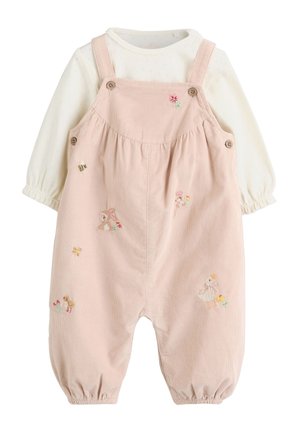 Bebé con cabello oscuro tumbado sobre una manta beige acolchada con rayas, vestido con un mono rosa con bordado de animales y una camiseta de manga larga crema.