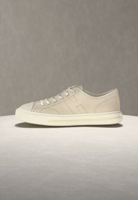 Μπεζ χαμηλή μπαλαρίνα από καμβά με λευκή λαστιχένια σόλα, κορδόνια και διακριτική ραφή σε ουδέτερο φόντο.