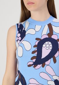 Πλεκτό αμάνικο τοπ σε ανοιχτό μπλε χρώμα, με λουλουδάτα σχέδια σε ναυτικό μπλε, ροζ και λευκό. Ριμπέ πλεκτή λαιμόκοψη, απαλή υφή.