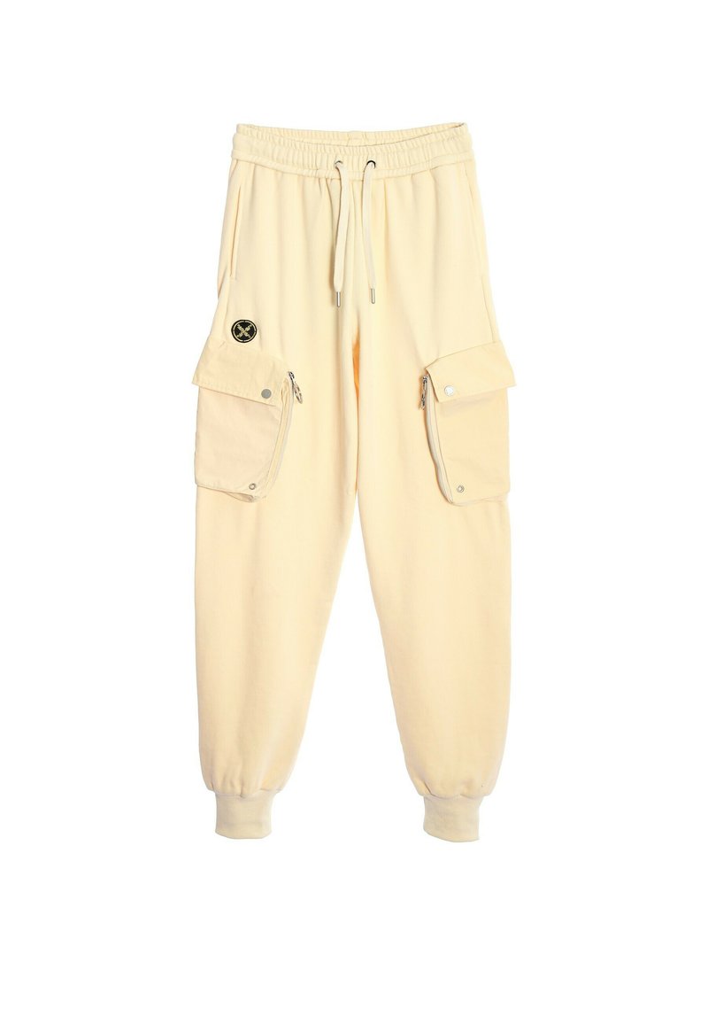 Pantalones cargo de color crema con puños elásticos, una cintura con cordón y dos grandes bolsillos laterales con cierres a presión.
