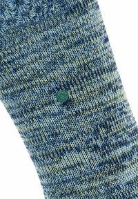 Calzino a motivi blu e verdi con un knit testurizzato. Presenta un accento circolare verde vicino al centro.