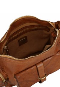 Borsa in pelle marrone con finitura testurizzata, dotata di chiusura con zip, tasche interne e dettagli in ottone. Interno in tessuto beige.
