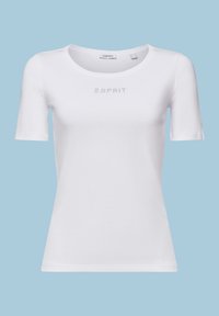 T-shirt blanc ajusté à manches courtes avec encolure ronde et petit logo Esprit en strass sur la poitrine, présenté sur fond bleu clair.