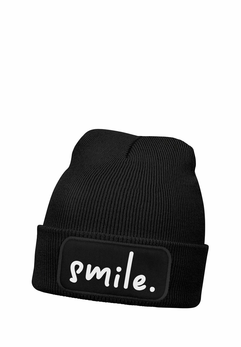 Black knit beanie with a ribbed texture. Features a black patch with the word "smile." in white, centered on the front.
