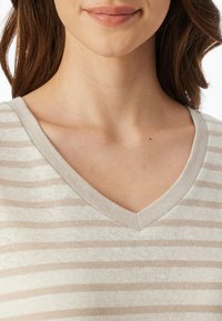 Beige gestreepte v-hals tuniek met een zachte katoenen textuur. Heeft afwisselend lichte en donkere strepen in een ontspannen pasvorm rond de halslijn.