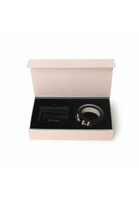 Scatola regalo contenente un portafoglio in pelle nera e un cinturino per orologio multi-colore con accenti dorati, adagiati su una fodera di velluto nero.