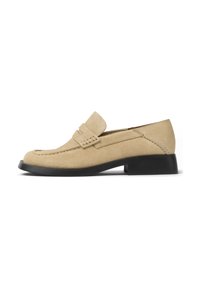 Beige suede loafers with a moccasin design, featuring a raised stitching detail and a low black rubber heel. Smooth texture and minimal accents.