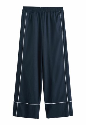 Tengerészkék bőszárú nadrág fehér csíkozással az oldalak mentén és az alsó szegélyeken, rugalmas derékpánttal és első zsebekkel.