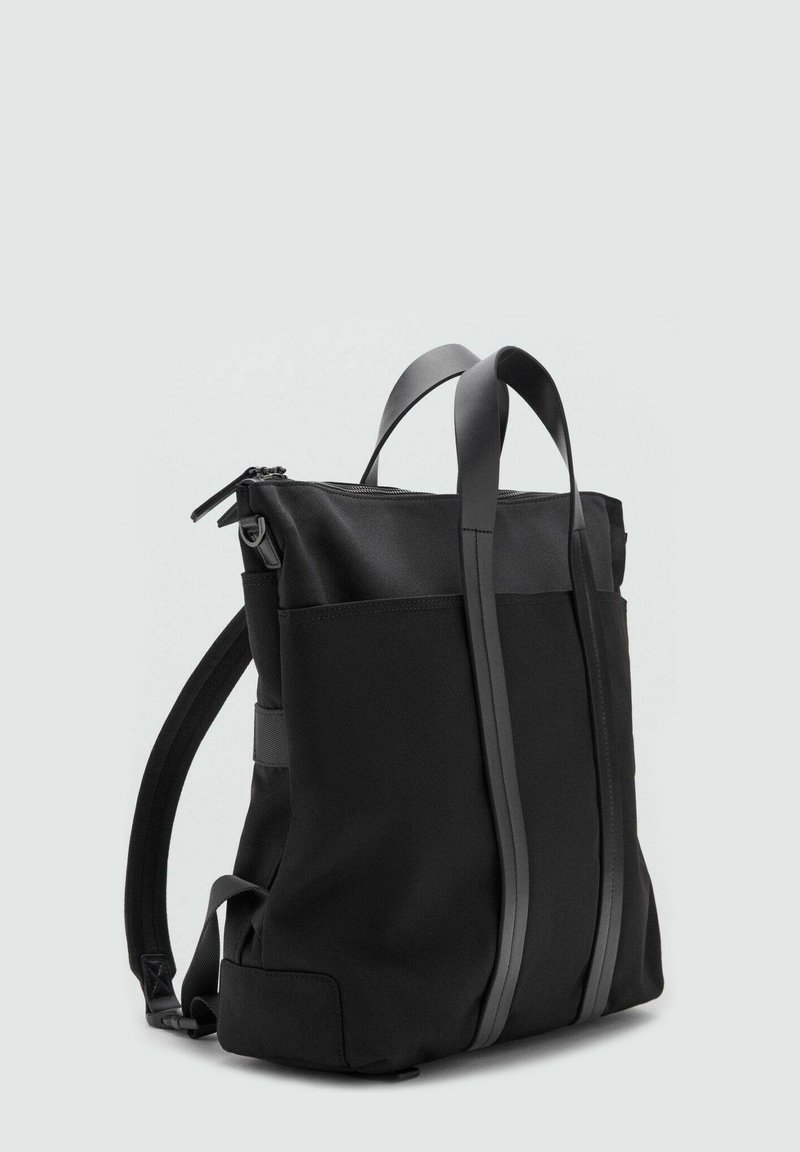Zaino nero realizzato in tessuto durevole, con due cinghie verticali, chiusura con cerniera e un design strutturato con tasche laterali.