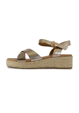 Wedge sandal with metallic gold crisscross straps and ankle buckle, featuring a braided jute platform sole.