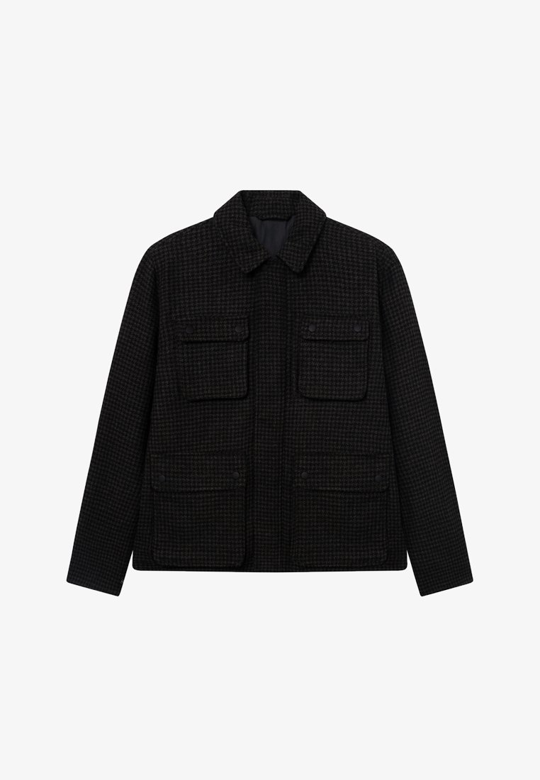 Μαύρο σακάκι σε σχέδιο houndstooth με γιακά, δύο μπροστινές τσέπες με καπάκι και ευθεία γραμμή. Φτιαγμένο από υλικό με υφή, κατάλληλο για στρώσεις.