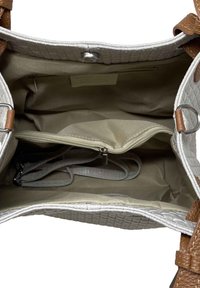 Avoin beigen värinen käsilaukku, jonka sisätilassa on useita osastoja, vetoketjullinen tasku sekä ruskeat nahkakahvat ja yksityiskohdat.